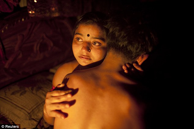 Seventeen-year-old prostitute Hashi, embraces a Babu, her "husband", inside her small room at Kandapara brothel in Tangail [file photo]