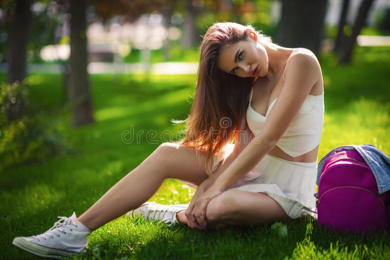 Beautiful sexy young blonde woman wearing in a white vintage suit and a blue jeans jacket. Beautiful sexy young blonde woman with long wavy hair thin slender stock image