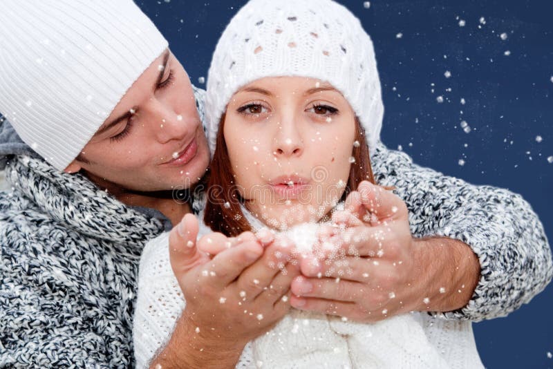 Christmas or new year wishes. Young couple blowing christmas or new year eve wishes or resolutions royalty free stock image