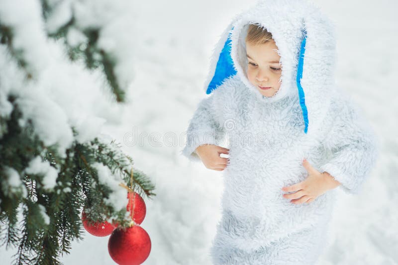 A little boy dressed as rabbit meets new year. Portraita little boy dressed as rabbit in winter forest. Child with christmas wreath. Snowy park. character xmas stock photography