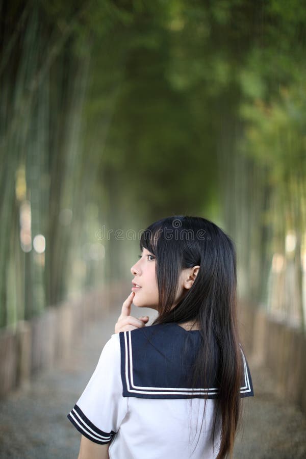 Portrait of beautiful Asian japanese high school girl uniform looking with bamboo forest background. Portrait of beautiful Asian japanese high school girl royalty free stock photo