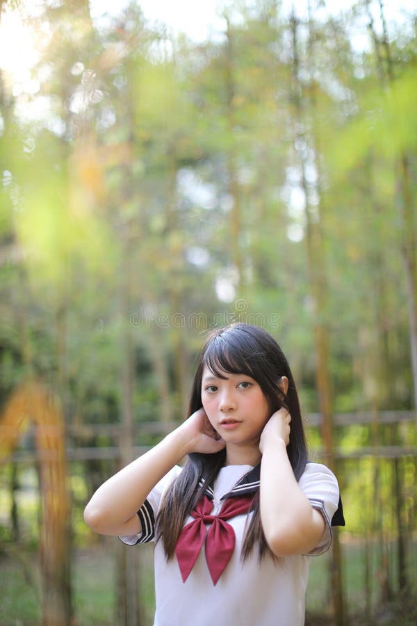 Portrait of beautiful Asian japanese high school girl uniform looking with bamboo forest background. Portrait of beautiful Asian japanese high school girl royalty free stock images