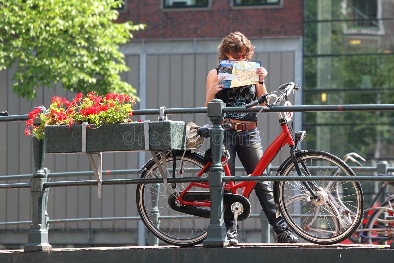 Tourist with map and bicycle. Amsterdam, Netherlands. stock photos