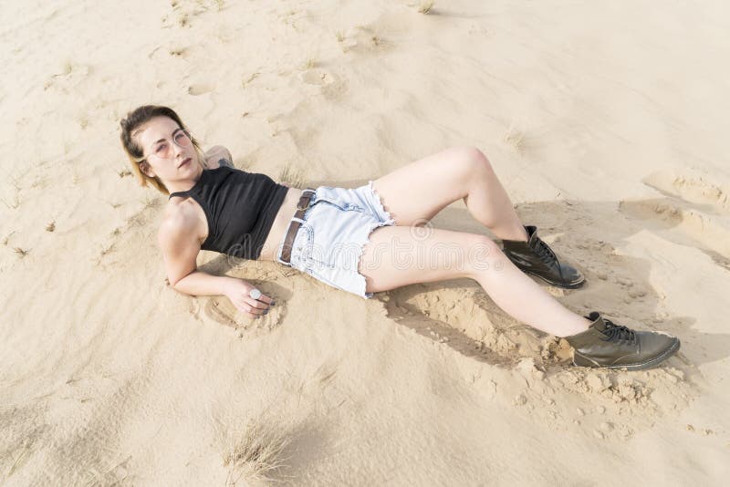 Woman lying in the sand royalty free stock image